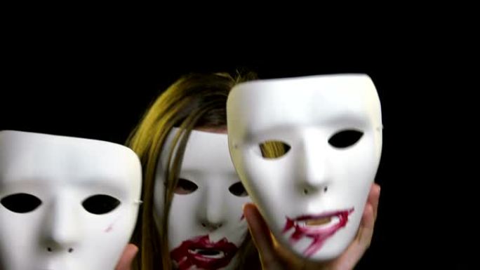 戴着恐怖面具的女人跳舞，拿着两个面具