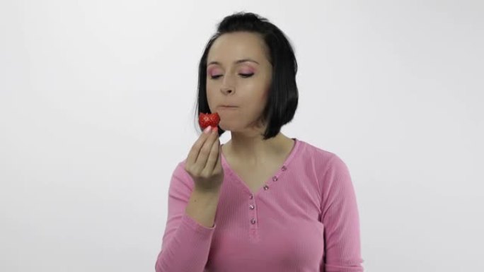 女人吃草莓，说好吃。女孩第一口说想咬