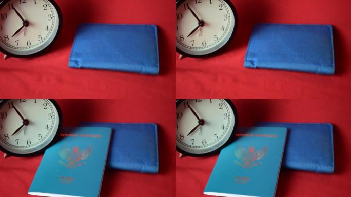 特写时钟，蓝色钱包和护照，隔离在红色背景