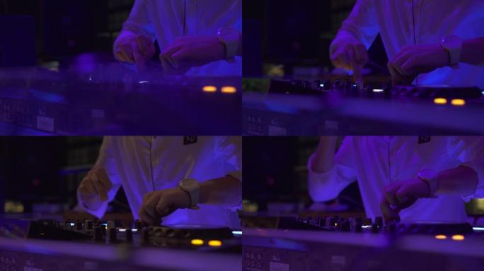 男子DJ在夜总会派对上在音响控制台播放舞蹈音乐。DJ控制器，用于在夜总会混合音乐和彩色灯光。舞会上的