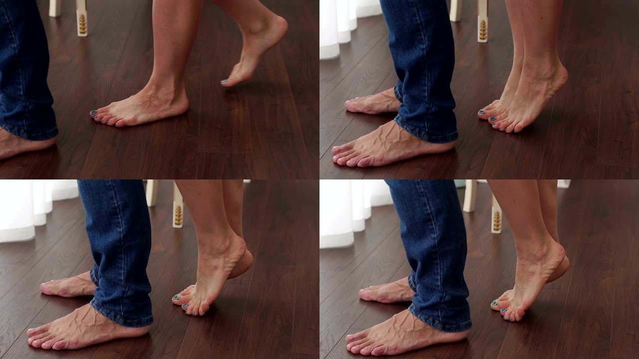 特写一对相爱的夫妇的光脚，女孩站在她的脚趾。