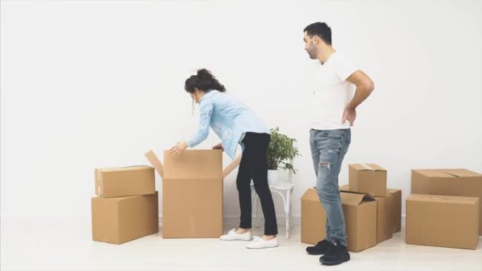 年轻夫妇正在一起搬到新公寓。他们正在考虑从什么开始。突然，女孩打开一个盒子，一个气球飞了起来。惊讶。