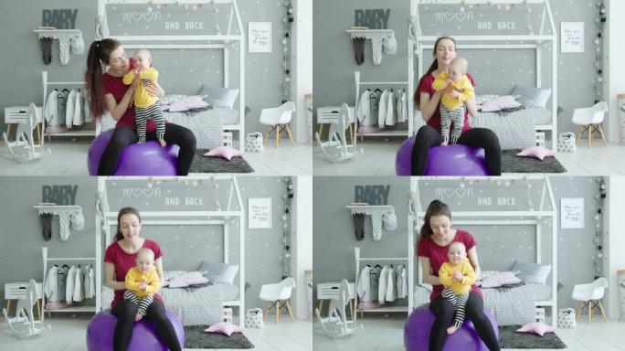 可爱的宝宝喜欢妈妈在球上的健身锻炼