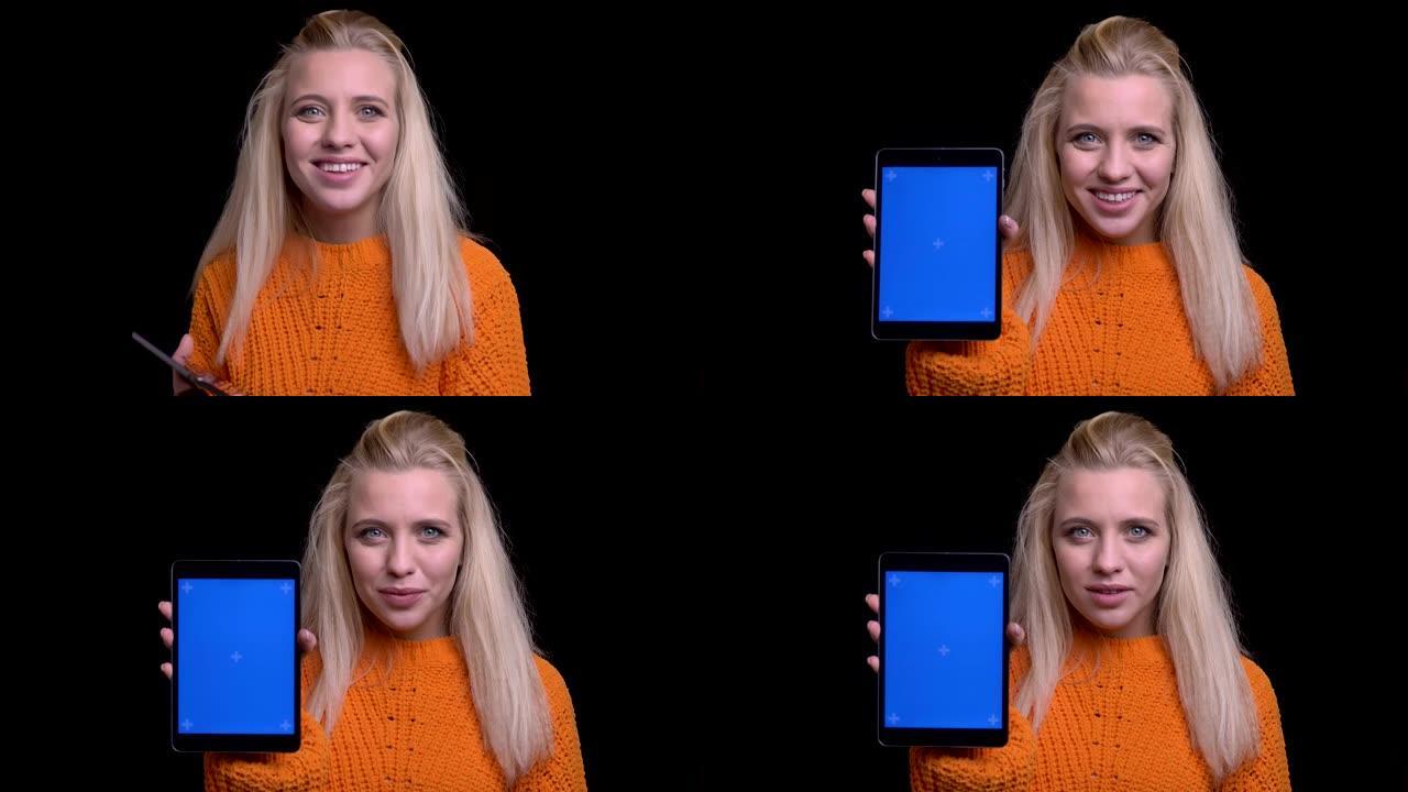 使用平板电脑拍摄年轻迷人的高加索女性的特写镜头，并向相机微笑显示蓝色色度屏幕