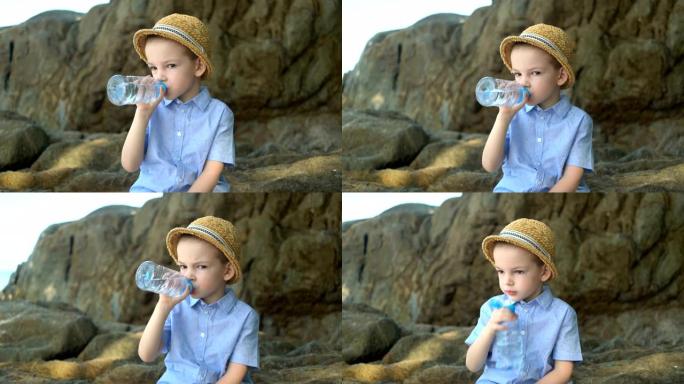 英俊可爱的男孩在晴天喝塑料瓶中的清水