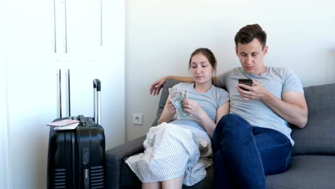 男人和女人选择经济型酒店休息，使用智能手机计算钱。