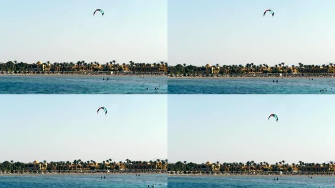 风筝冲浪的降落伞在清澈的蓝天下盘旋在水边。夏天，在海滩上
