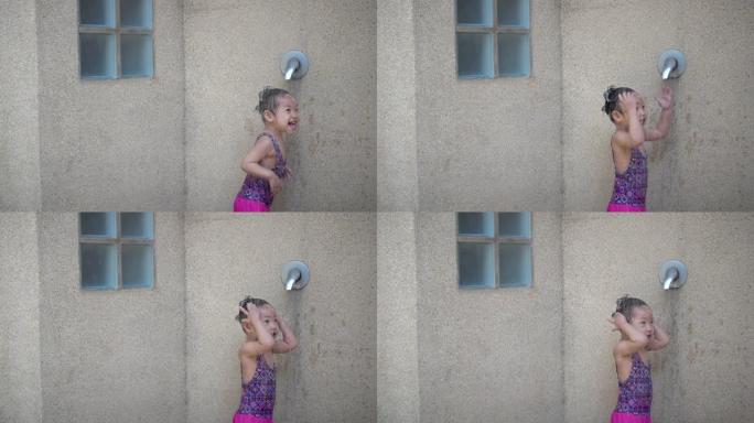 亚洲女婴游泳后享受淋浴的乐趣，慢动作拍摄。