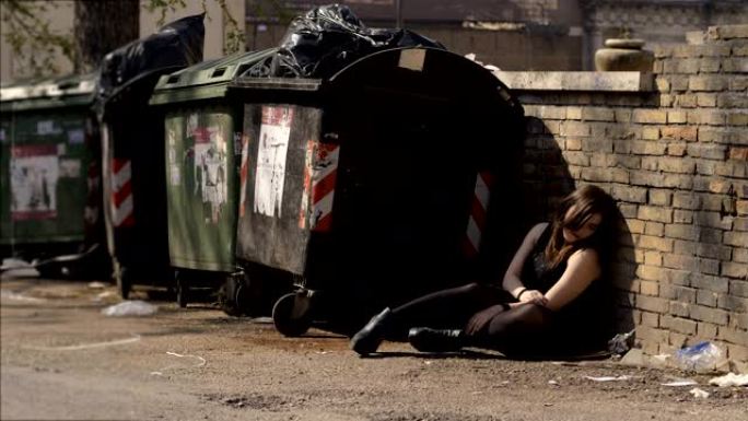 成瘾，吸毒，孤独。吸毒成瘾的女人坐在肮脏的街道上哭泣