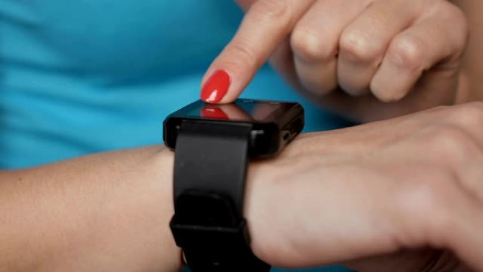 女人使用她的智能手表触摸屏可穿戴技术设备。女人使用她的智能手表触摸屏可穿戴技术设备。女孩在可穿戴智能