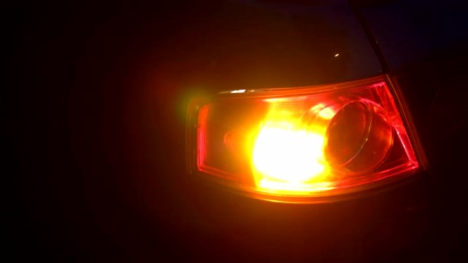 夜间停在侧面的汽车上闪烁橙色闪光灯