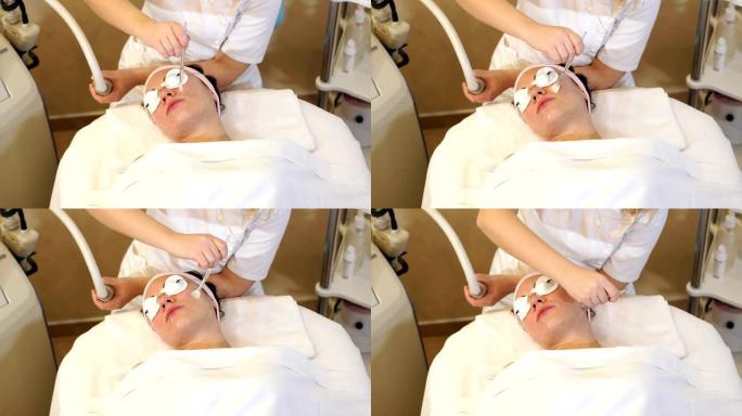 一名妇女在水疗中心接受清洁和提升面部皮肤的程序。