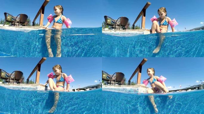 可爱的袖章小女孩在泳池边缘尽情享受，半水下视角，慢动作