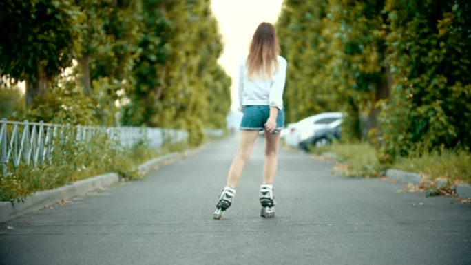 一个十几岁的女孩在空旷的道路上滑冰。
