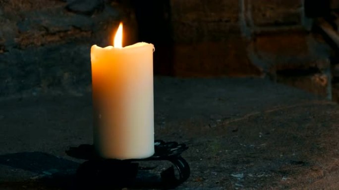 大蜡白蜡烛燃烧并站在旧烛台上