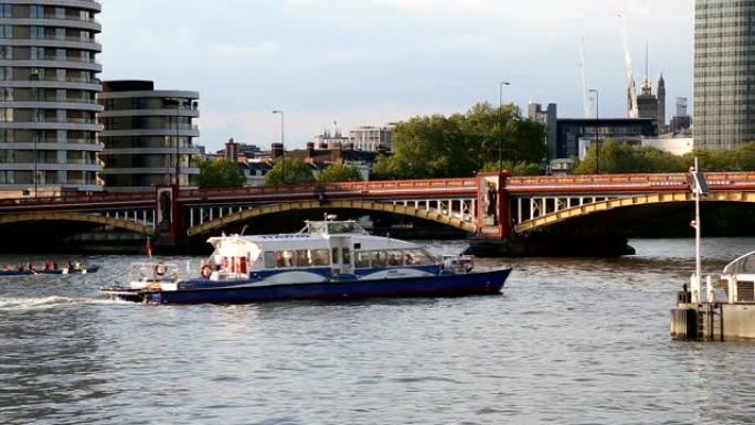 独木舟和渡轮经过伦敦泰晤士河沃克斯豪尔桥下
