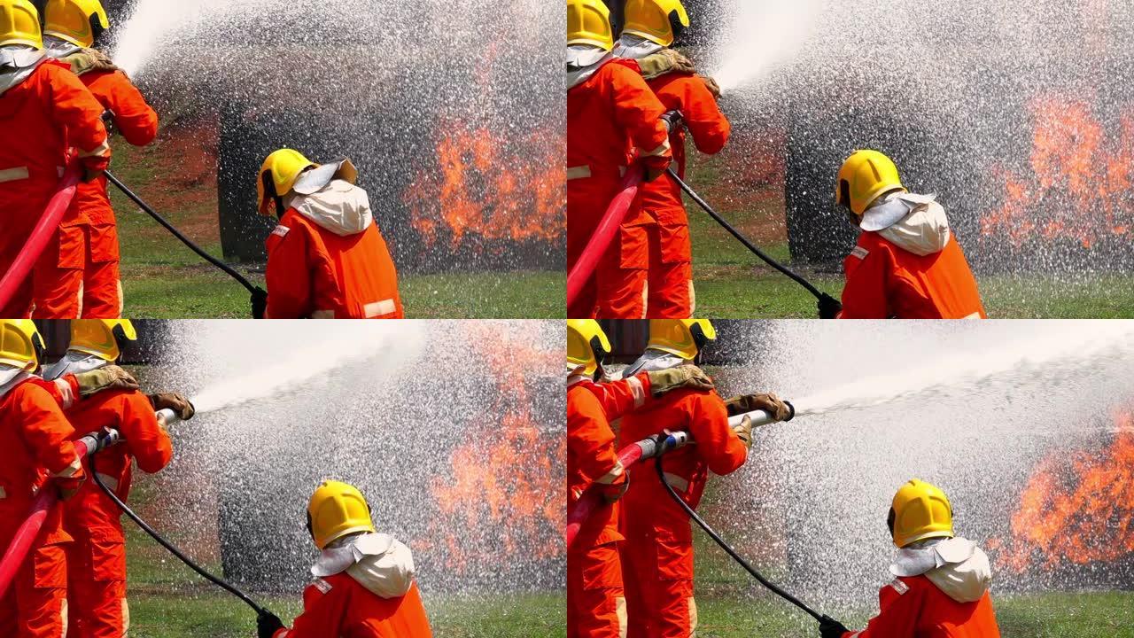 FHD 250 fps慢动作宽镜头消防员在安全救援任务中穿着消防服，燃烧的油车中有裂纹的火焰。三名消