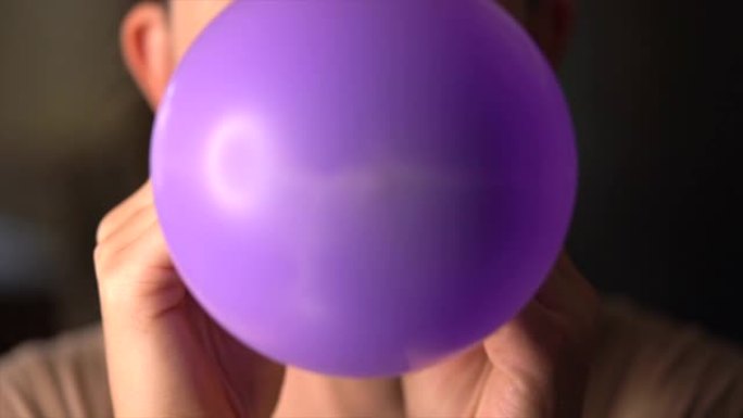 特写女人吹紫色气球