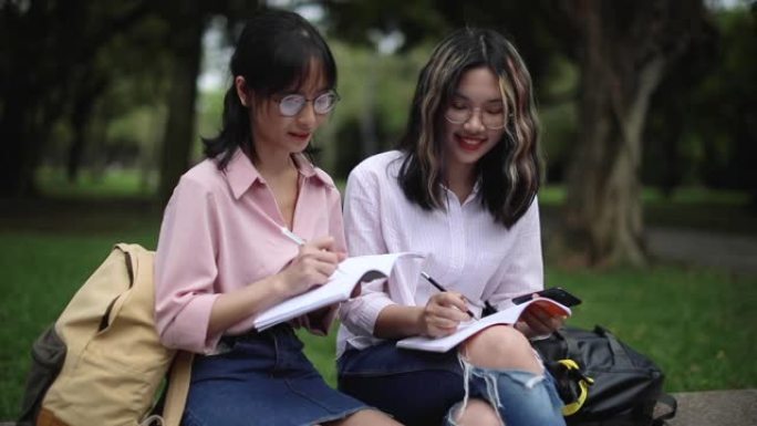台湾学生在公园用笔记本写字