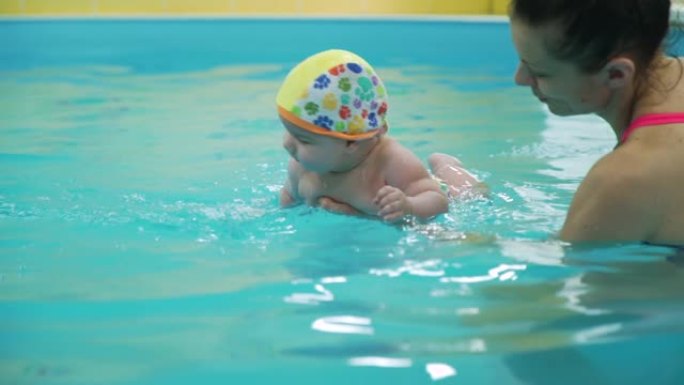 小男孩在游泳池里学习游泳
