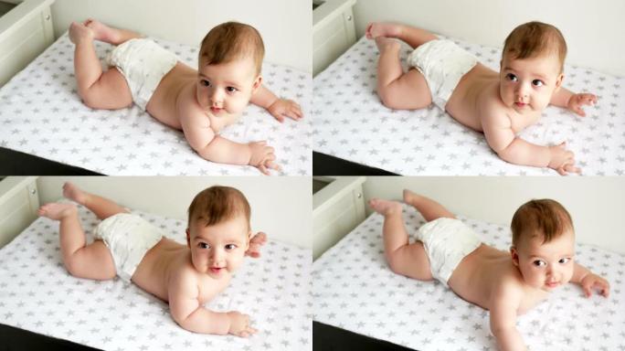 穿着尿布的男婴躺在她的肚子上，穿着星星的尿布