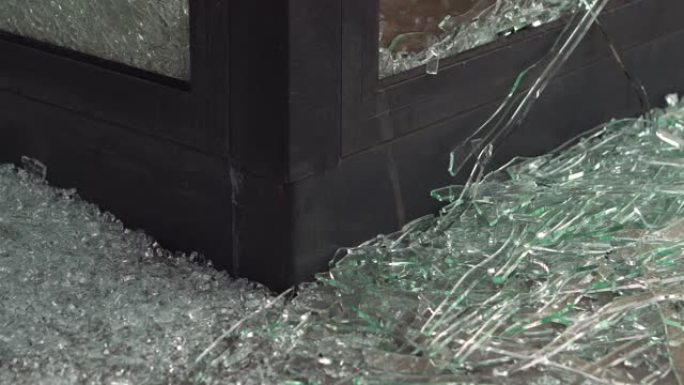玻璃破碎的窗框特写。窗户上的小块碎玻璃。故意破坏威胁私有财产。保险，安全系统和视频监控以保护财产