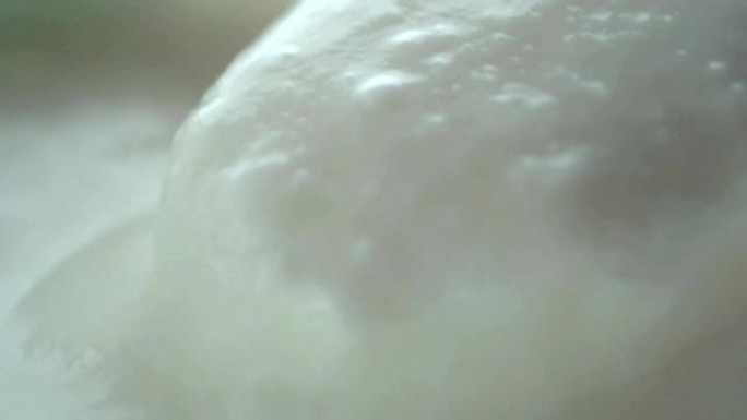微距视频拍摄，杯子里用勺子混合酸奶的慢动作