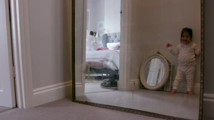 一个患有唐氏综合症的小女孩看着镜子里的自己