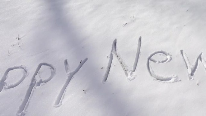 雪地上新年快乐的题词。冬天拍摄。