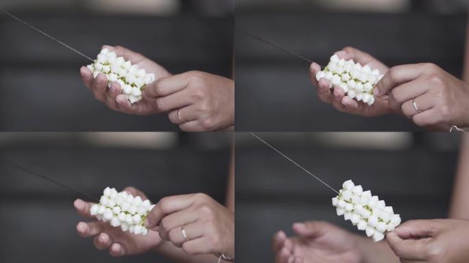 慢动作，年轻女子的手正在制作白色栀子花的美丽花环。