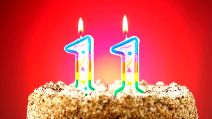 带有燃烧的生日蜡烛的生日蛋糕。11号。背景改变颜色