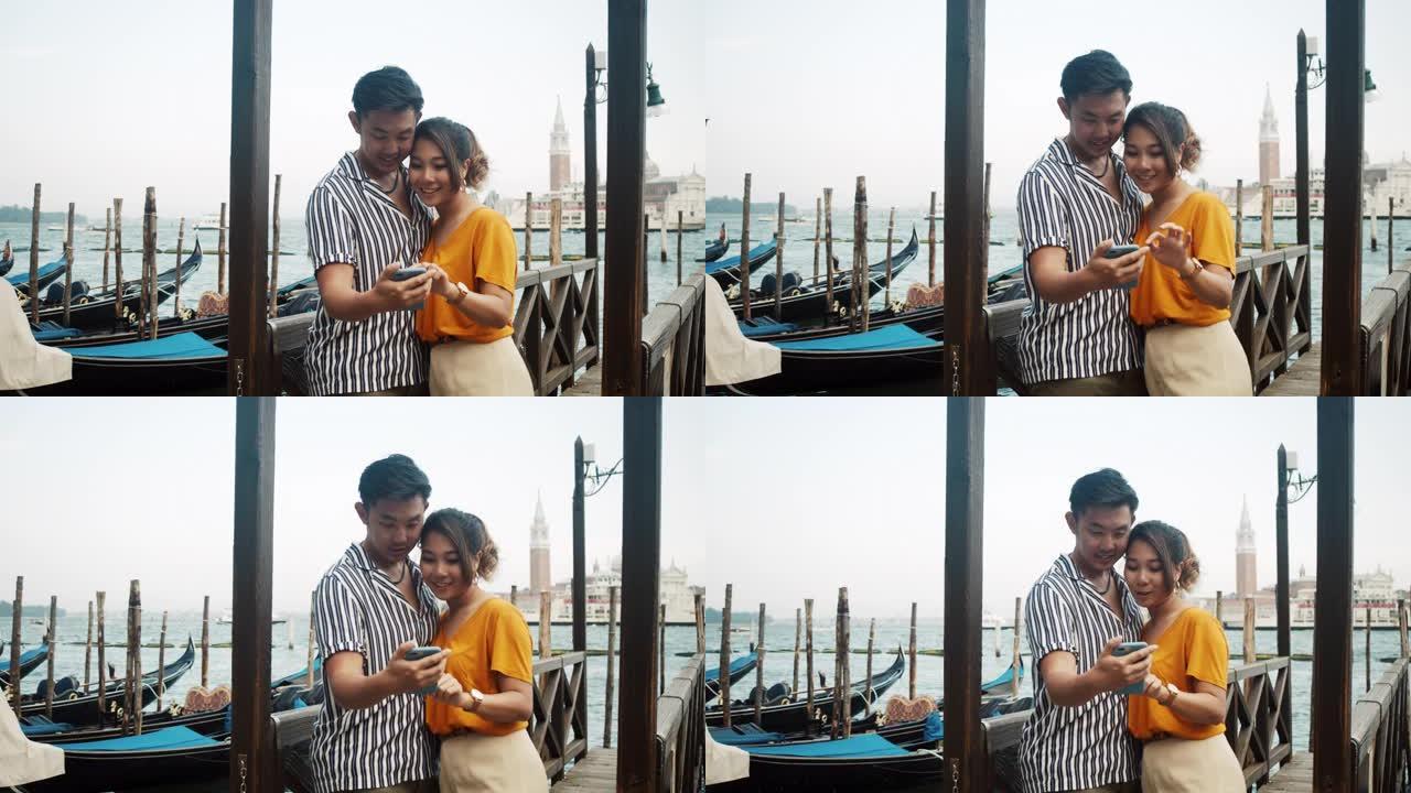 在意大利威尼斯使用手机的年轻成年亚洲夫妇