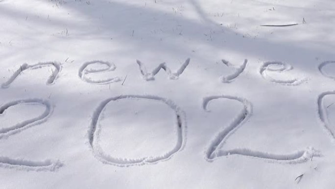 在雪地上题字新年。冬天拍摄。