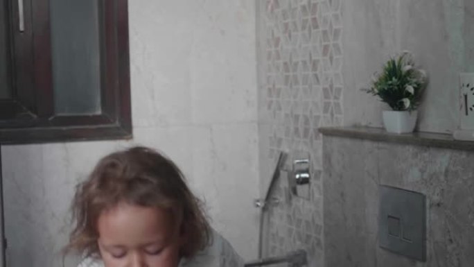 卷曲的小女孩用水漱口。