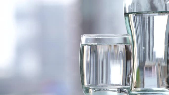 在桌子上的玻璃杯中喝水