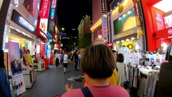 明洞市场的超延时。韩国首尔，人们晚上在购物街上散步
