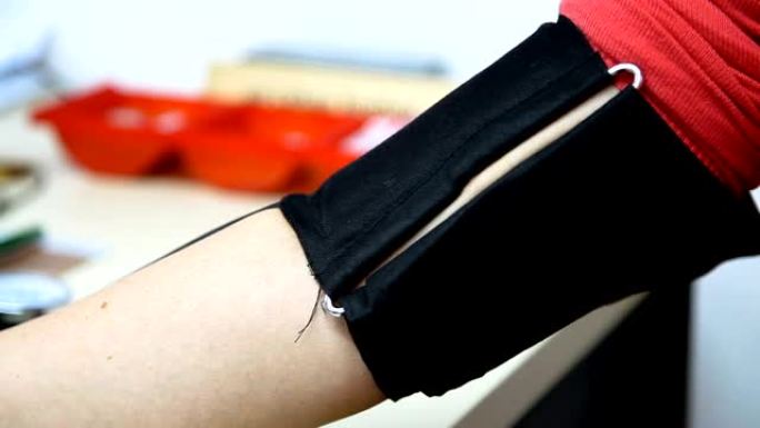 在女性手上放置血压测量装置的带子