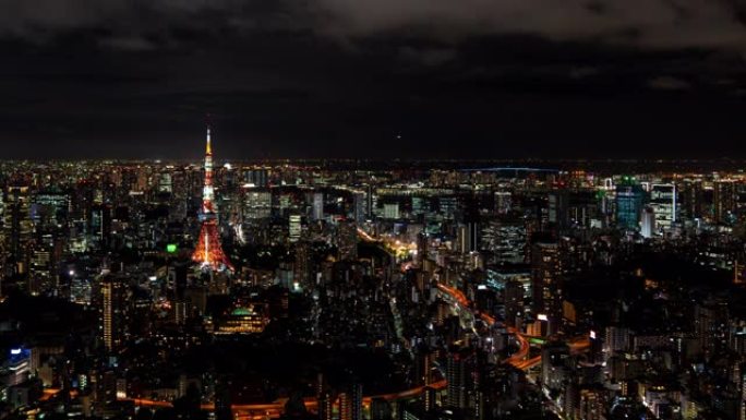 4k延时放大从日本东京六本木山夜间在摩天大楼城市景观商业金融大楼和东京塔上移动云层的宽镜头高角度鸟瞰