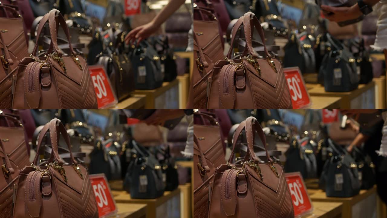 年轻女子在时尚服装和配饰商店选择合成革包。顾客女孩在购物中心购买手提包。折扣概念。4K