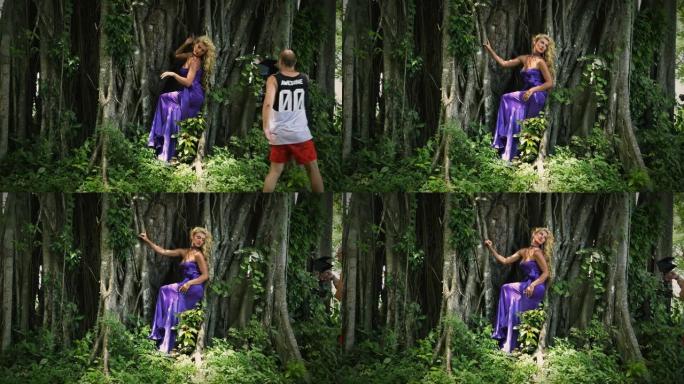 穿着紫色连衣裙的年轻女子在大树的背景上摆姿势