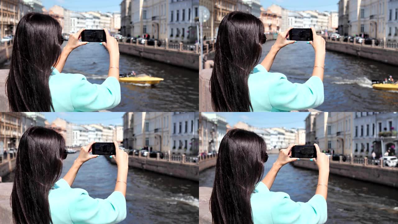 旅游妇女使用被历史名城包围的浮船河的智能手机拍照