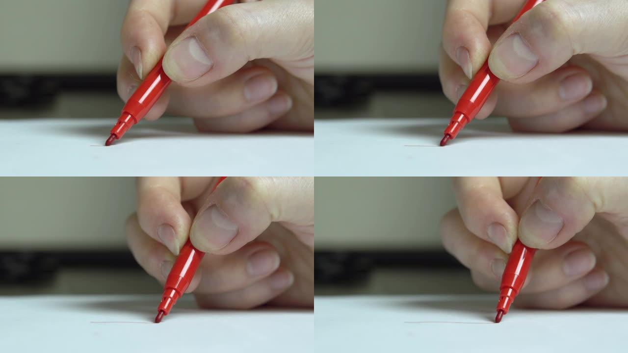 女人的手在白纸上用毡尖笔画画。特写。