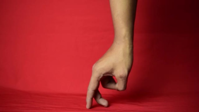 特写男性手显示行走标志，两个手指在红色背景上隔离