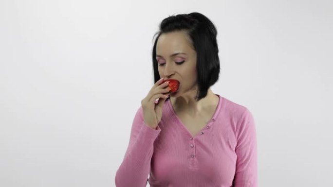 女人吃草莓，说好吃。女孩第一口说想咬