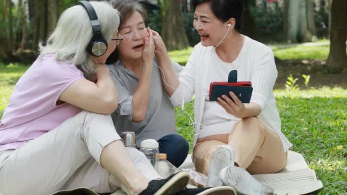 三位台湾老人朋友在公园听音乐