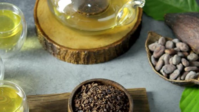 热可可茶。新鲜的热巧克力凉茶由可可豆片制成，富含类黄酮和抗氧化剂，可在眼镜中食用，选择性聚焦深色背景