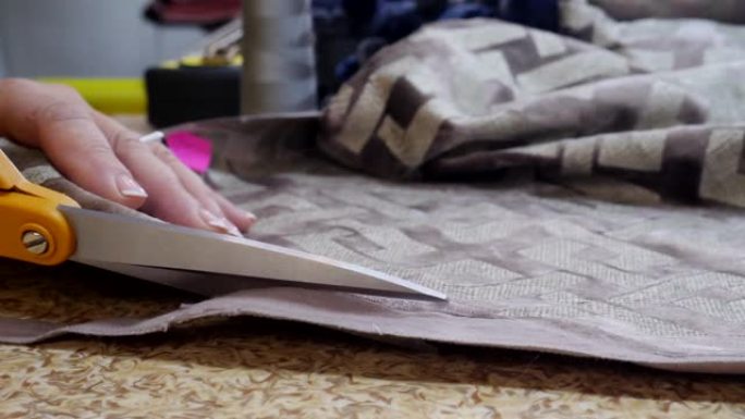 女裁缝的手切割纺织品或布料