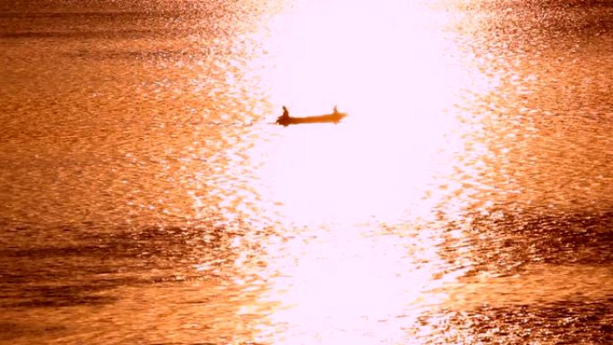 渔船的剪影在湖中钓鱼和日落背景