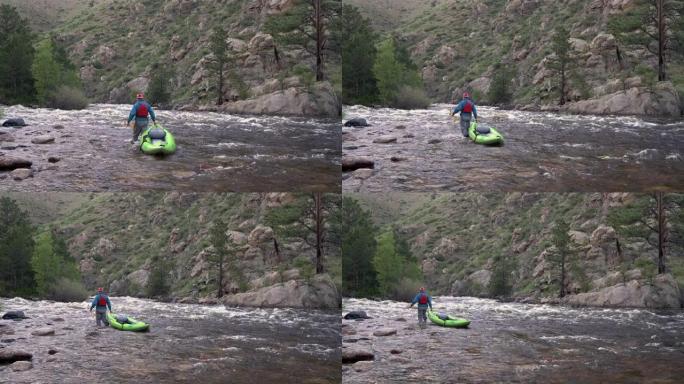 男性划桨手正在山河上游拖曳充气白水皮划艇