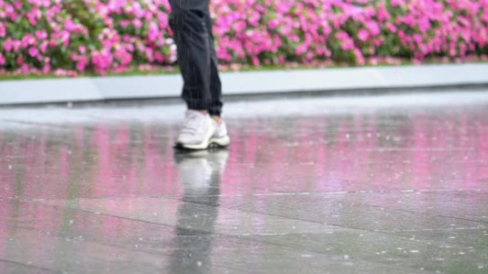 雨水滴落在沥青上的水坑中，淹没了街道。道路洪水由于雨季暴雨，超级慢动作，大雨落下背景，人们在雨中行走